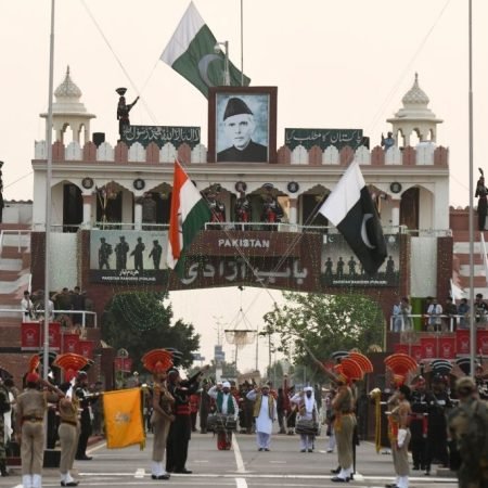 Indian Border Security Force (BSF) (front) personnel and Pakistani Rangers (in black) personnel lower their respective flags during the daily beating retreat ceremony on the eve of the 75th Pakistan Independence day on August 14, at the India-Pakistan Wagah Post some 35 km from Amritsar on August 13, 2021. (Photo by NARINDER NANU / AFP) (Photo by NARINDER NANU/AFP via Getty Images)